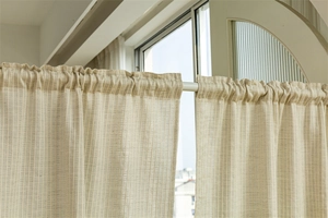 Close-up of beige cotton door curtain featuring vertical stripes and rod pocket ruffles
