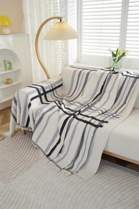 Close-up of waffle weave sofa cover with geometric stripes and natural fringe edges