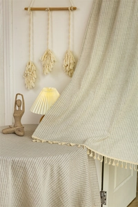 Detail of Japanese style cotton door curtain with beige stripes and delicate mini tassels