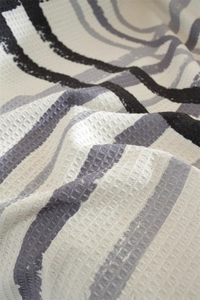 Close-up of geometric waffle weave fabric texture with modern wavy patterns