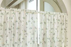 Detailed embroidery of green leaves and yellow flowers on a white cotton door curtain