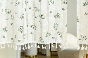 Detailed close-up of floral embroidery and white fringe tassels on cotton door curtain