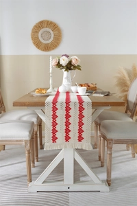 Detail of bohemian cotton linen table runner with red triangle embroidery and tassels