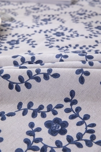 Detail of leaf print tablecloth with fringe tassels on soft cotton linen fabric