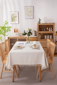 Close-up of cream rectangular PVC tablecloth with elegant tassel fringe edges