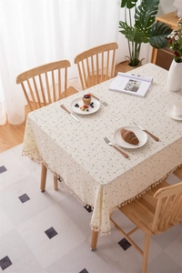 Detailed close-up of floral cotton tablecloth featuring fringe edges and yellow blossoms