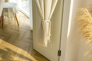Close-up of cotton striped door curtain with elegant tassels and braided rope tieback