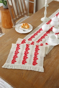 Detailed view of bohemian cotton table runner with red diamond weave and long tassels