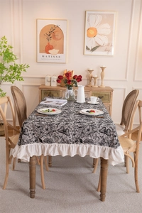Close-up of vintage black and white butterfly floral tablecloth with ruffled fringe edges