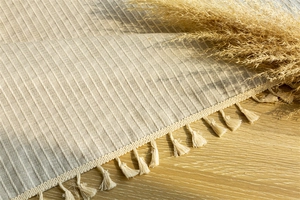 Detail of beige cotton linen door curtain with vertical stripes and delicate fringe tassels