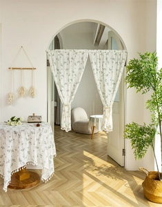 Detail of floral cotton door curtain with white tassels and elegant green leaf patterns