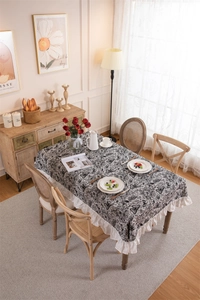 Close-up of vintage black and white butterfly floral tablecloth with white ruffled edges