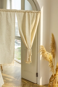 Close-up of linen blend room divider curtain featuring elegant tassel fringe and natural texture
