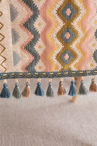 Macro shot of colorful geometric jacquard patterns and elegant tassel details on table runner