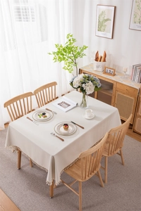 Detail of beige PVC tablecloth featuring decorative tassels and waterproof texture