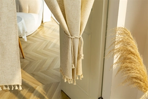 Close-up of linen blend door curtain featuring elegant bottom fringe and rustic texture