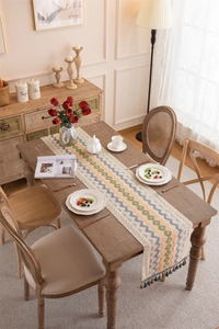 Close-up of woven table runner featuring colorful ripple patterns and navy blue tassels