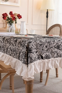 Detail of vintage black and white butterfly floral tablecloth with ruffled fringe edges