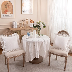 Detailed view of white embroidered cotton pillowcase with French ruffle edges and lace