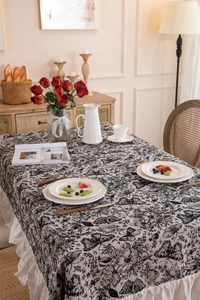 Close-up of vintage black and white butterfly print tablecloth with white ruffled edges
