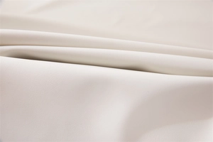 Detailed macro view of cream PVC tablecloth with fine faux leather grain and soft texture