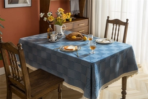 Détail de la nappe jacquard géométrique bleu foncé avec bordure à franges blanc crème