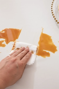 Waterproof white PVC tablecloth detail showing high oil resistance with coffee spill droplets