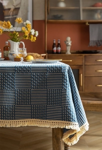 Détail de la nappe tissée géométrique bleu et blanc avec d'élégants pompons à franges