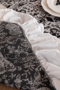 Close-up of vintage black and white butterfly jacquard tablecloth with ruffle fringe