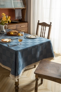 Gros plan sur la nappe jacquard géométrique bleu marine avec franges à pompons rustiques