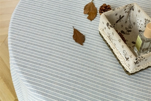Detail of blue and white striped cotton fabric with natural woven texture and tassels