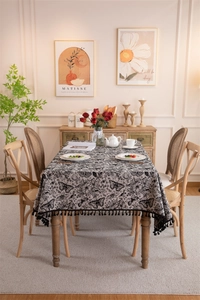 Close-up of black and white butterfly floral tablecloth with elegant black fringe edge