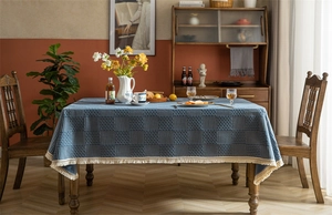 Gros plan sur la nappe jacquard à carreaux bleu marine avec d'élégants glands à franges crème
