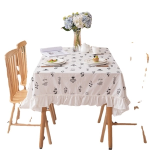 Floral cotton tablecloth with elegant ruffled edges and black embroidery on a beige base