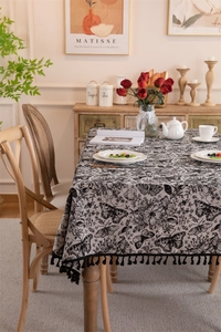 Detailed close-up of vintage black and white butterfly floral pattern with tassel edge