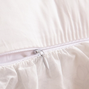 Detail of hidden zipper and ruffle edges on white cotton embroidered pillowcase