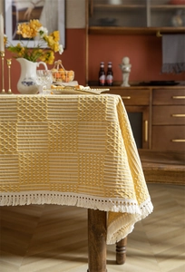Détail de nappe jaune à carreaux géométriques avec texture tissée et franges en coton