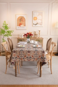 Detail of vintage floral jacquard tablecloth with bird patterns and fringe tassels