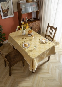 Gros plan d'une nappe à carreaux jaune avec bordure en dentelle blanche et texture