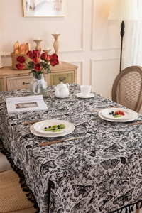 Macro detail of vintage black and white butterfly floral tablecloth with bead fringe tassels