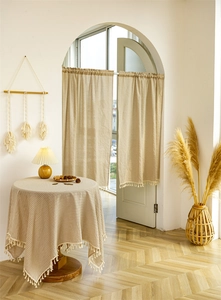 Close-up of beige cotton linen fabric with white stripes and delicate tassel fringe