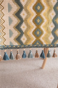 Close-up of geometric jacquard table runner with decorative dual-tone tassel fringe