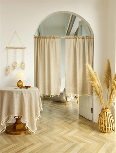 Detail of beige striped cotton door curtain and tablecloth set with fringe tassels