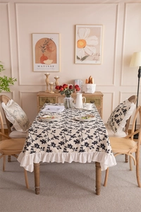 Detail of French floral tablecloth with elegant ruffle edge on a wooden table