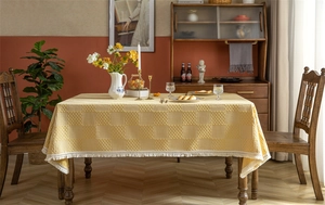 Détail macro de la nappe en jacquard jaune pâle avec texture à carreaux et dentelle blanche