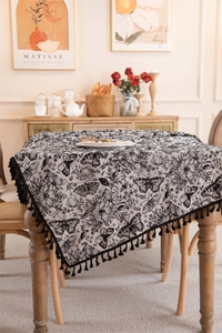 Close-up of vintage black butterfly pattern tablecloth with elegant black fringe tassels