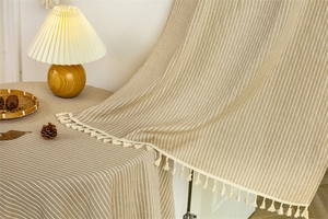 Close-up of cotton door curtain with vertical stripes and delicate tassel fringe detail