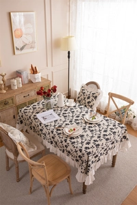 Detail of floral print tablecloth featuring ruffled edges and vintage botanical patterns
