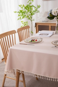 Detail of pink PVC tablecloth with elegant white cotton tassels and thick drape texture