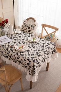 Close-up of elegant floral tablecloth featuring delicate white ruffled edges and textures